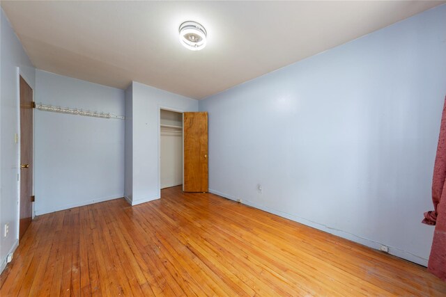 71-34 Kissena Blvd, Flushing, NY 11367 - unfurnished bedroom featuring light wood-type flooring, a closet, and baseboards
