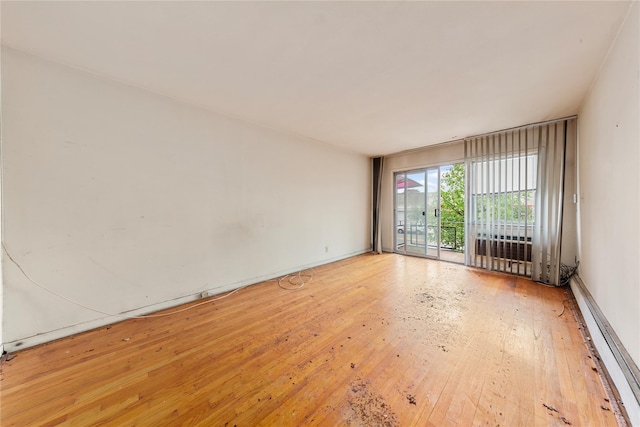 71-34 Kissena Blvd, Flushing, NY 11367 - empty room with hardwood / wood-style floors, a baseboard heating unit, and baseboards