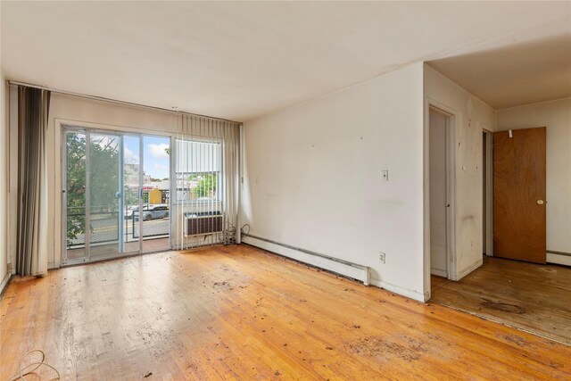 71-34 Kissena Blvd, Flushing, NY 11367 - spare room featuring a baseboard heating unit, hardwood / wood-style floors, and baseboards