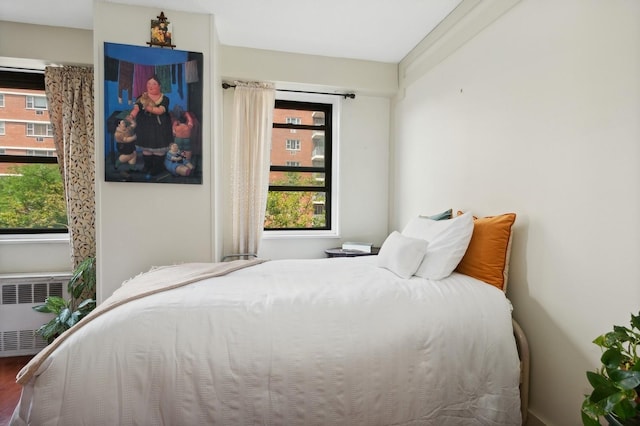 39-60 54th St Unit 3B, Woodside, NY 11377 - bedroom with multiple windows, radiator heating unit, and wood finished floors