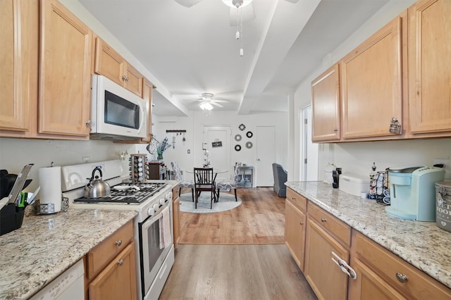 135 Highland Ave S Unit D1, Ossining, NY 10562 - kitchen with a ceiling fan, white appliances, light wood-style flooring, and light stone counters