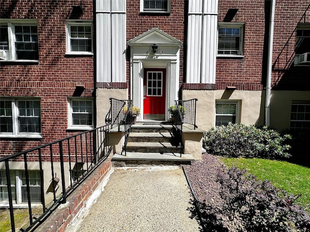view of exterior entry featuring brick siding and cooling unit