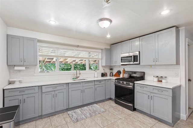 21 Wagon Ln, Brewster, NY 10509 - kitchen featuring stainless steel appliances, gray cabinets, a sink, tasteful backsplash, and light countertops