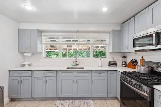 21 Wagon Ln, Brewster, NY 10509 - kitchen featuring stainless steel appliances, gray cabinetry, a sink, backsplash, and recessed lighting