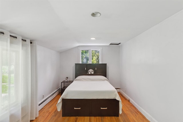 21 Wagon Ln, Brewster, NY 10509 - bedroom with baseboard heating, light wood-style floors, vaulted ceiling, baseboards, and a baseboard radiator
