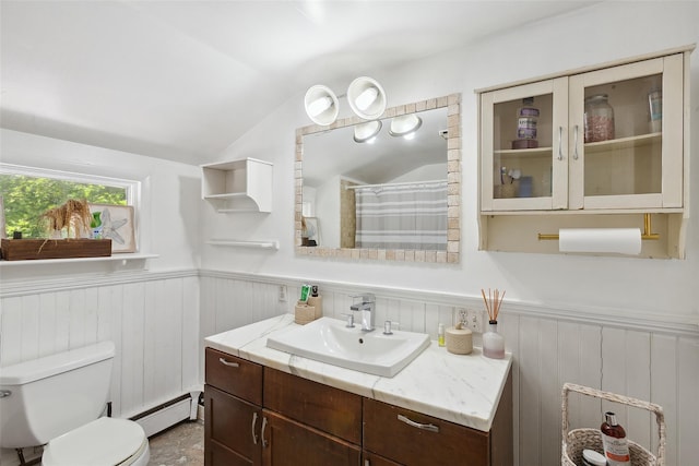 21 Wagon Ln, Brewster, NY 10509 - bathroom featuring a baseboard heating unit, vanity, vaulted ceiling, wainscoting, and toilet