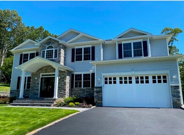 85 Roundtree Dr, Plainview, NY 11803 - craftsman-style home with stone siding, asphalt driveway, a garage, and a front lawn