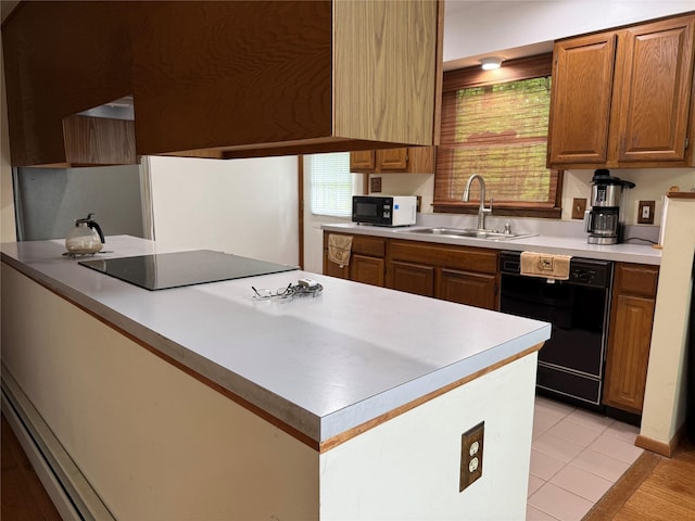 kitchen featuring black appliances, a sink, brown cabinets, light countertops, and light tile patterned floors
