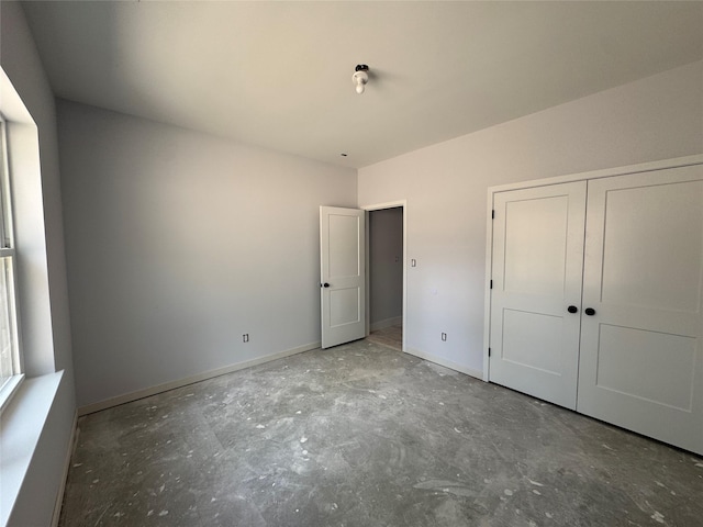 40 Wells Rd, Newburgh, NY 12550 - unfurnished bedroom with unfinished concrete flooring, baseboards, and a closet