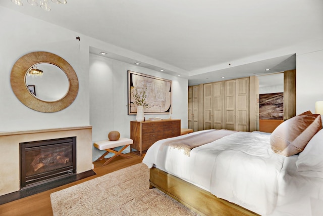 212 E 95th St, New York Manhattan, NY 10128 - bedroom with wood finished floors, recessed lighting, and a fireplace with flush hearth