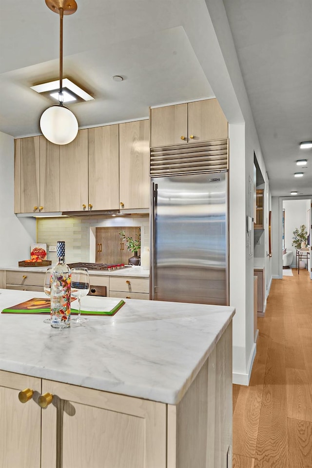 212 E 95th St, New York Manhattan, NY 10128 - kitchen with built in fridge, light brown cabinetry, backsplash, and light wood-style floors