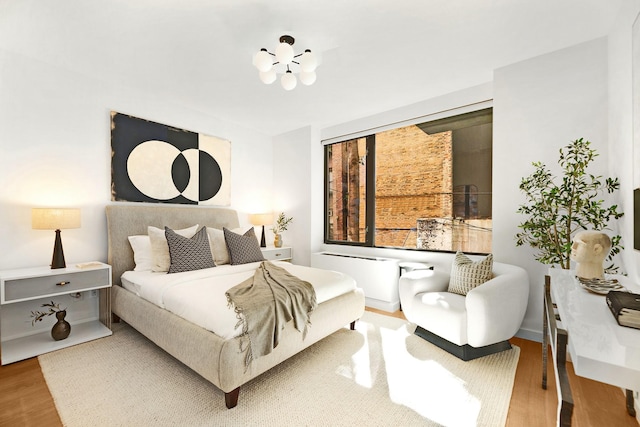 212 E 95th St, New York Manhattan, NY 10128 - bedroom featuring wood finished floors and a chandelier