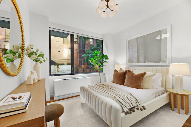 212 E 95th St, New York Manhattan, NY 10128 - bedroom with wood finished floors, radiator heating unit, and a chandelier
