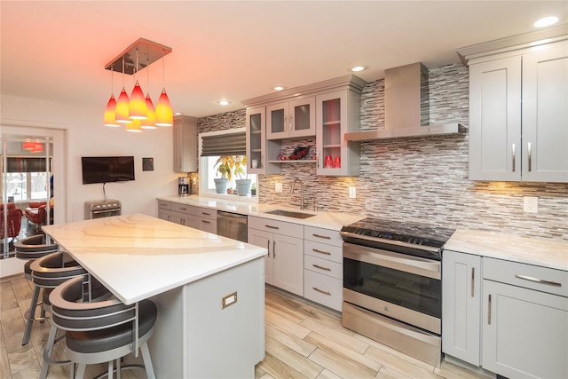 129 Boardman Rd, Poughkeepsie, NY 12603 - kitchen with wall chimney range hood, stainless steel appliances, a sink, a breakfast bar, and decorative backsplash