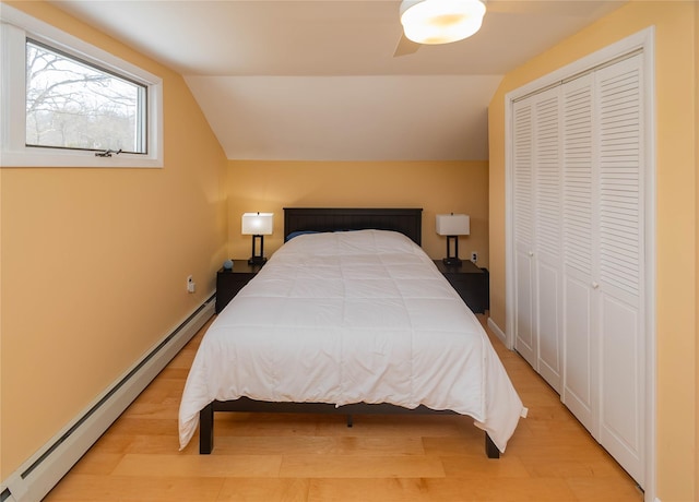 129 Boardman Rd, Poughkeepsie, NY 12603 - bedroom featuring baseboard heating, lofted ceiling, a closet, and light wood-style floors