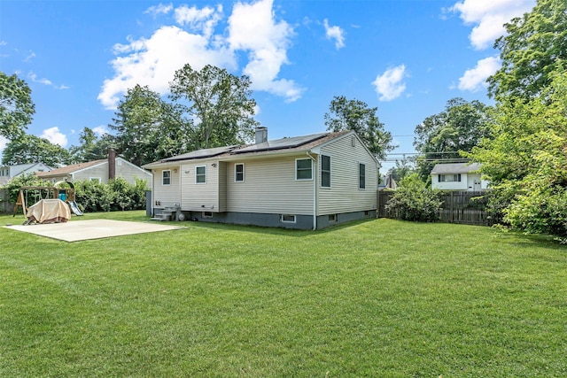 51 Andrews Ave, Wyandanch, NY 11798 - rear view of house with roof mounted solar panels, a patio area, and a chimney
