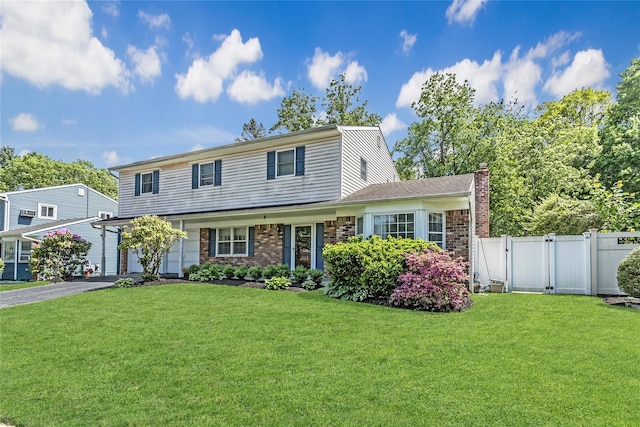 721 3rd Ave, East Northport, NY 11731 - traditional home with a gate, asphalt driveway, a garage, brick siding, and a chimney