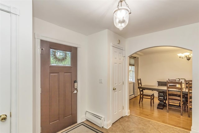 721 3rd Ave, East Northport, NY 11731 - foyer entrance featuring arched walkways, a baseboard heating unit, light tile patterned floors, and baseboards