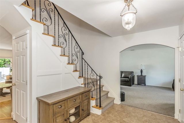 721 3rd Ave, East Northport, NY 11731 - stairs featuring arched walkways, carpet floors, tile patterned flooring, and baseboards