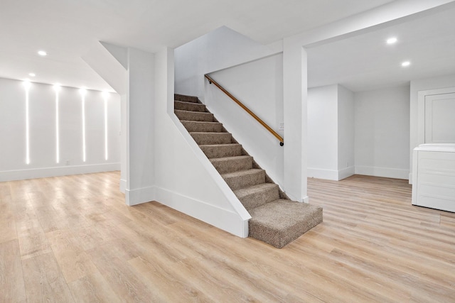 stairway featuring recessed lighting, wood finished floors, and baseboards