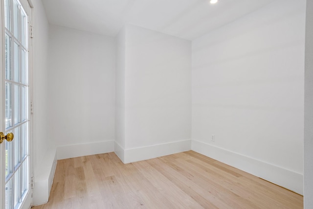 spare room featuring light wood-style flooring, plenty of natural light, and baseboards