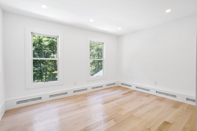 empty room with wood finished floors and recessed lighting