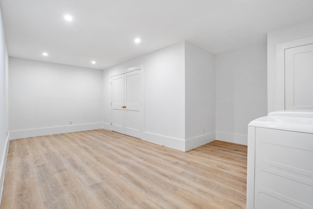 spare room featuring light wood-style floors, recessed lighting, baseboards, and washer / dryer