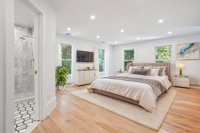 bedroom with recessed lighting, multiple windows, wood finished floors, connected bathroom, and baseboards