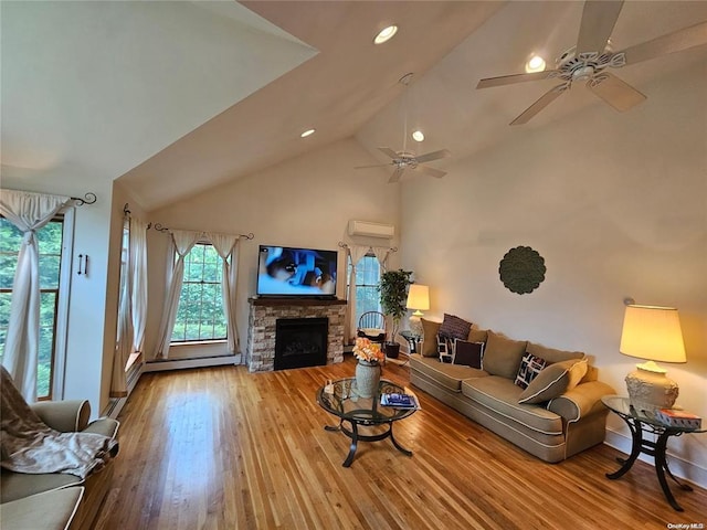 living room featuring lofted ceiling, wood finished floors, a ceiling fan, a stone fireplace, and a wall mounted AC