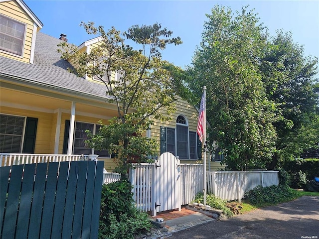 view of home's exterior featuring fence and roof with shingles