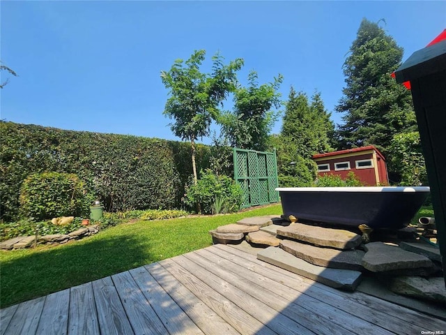 wooden deck featuring an outbuilding and a storage unit