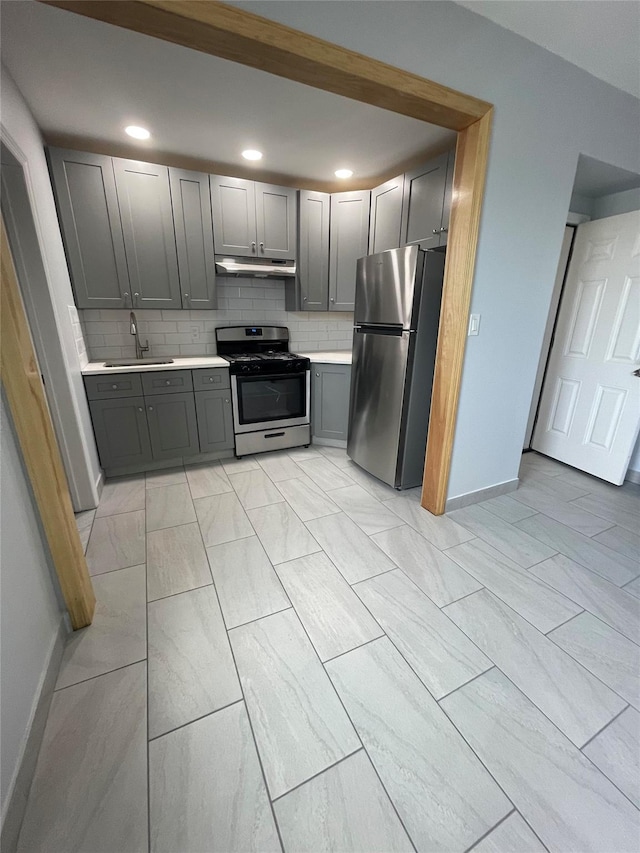 5431 Nurge Ave, Maspeth, NY 11378 - kitchen with appliances with stainless steel finishes, gray cabinetry, under cabinet range hood, light countertops, and a sink