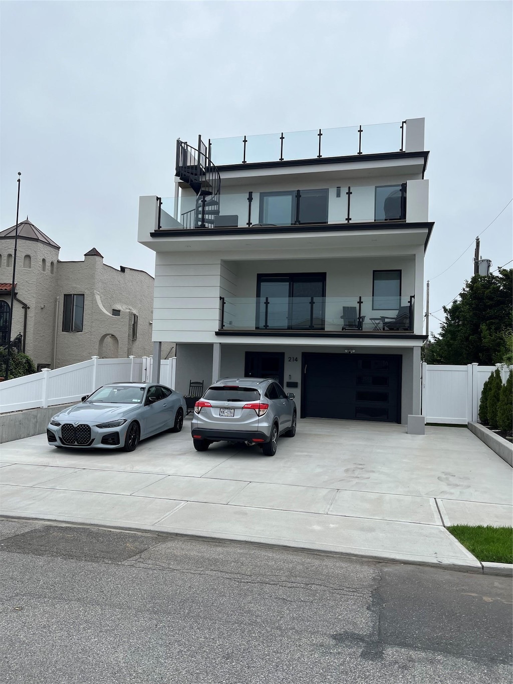 535 E Olive St, Long Beach, NY 11561 - view of front facade featuring driveway, a balcony, and an attached garage