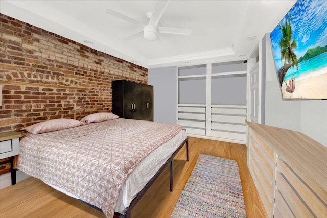 1185 Anderson Ave Unit 1F, Bronx, NY 10452 - bedroom featuring wood finished floors, brick wall, a ceiling fan, and a raised ceiling