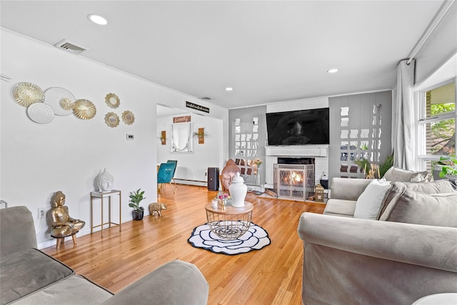 63 Wright Blvd, Hopewell Junction, NY 12533 - living room with a baseboard heating unit, wood finished floors, a brick fireplace, recessed lighting, and baseboards