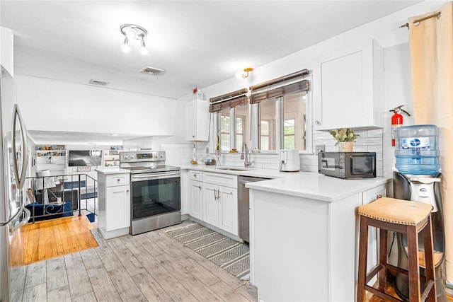 63 Wright Blvd, Hopewell Junction, NY 12533 - kitchen featuring appliances with stainless steel finishes, a peninsula, a sink, and decorative backsplash