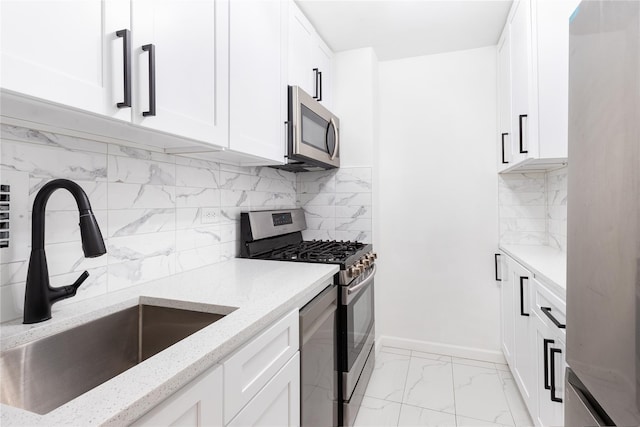 2500 Johnson Ave Unit 3B, Bronx, NY 10463 - kitchen with stainless steel appliances, a sink, light stone countertops, light marble finish flooring, and white cabinets