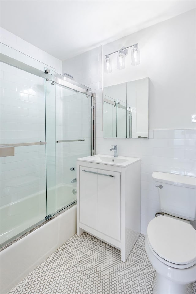 2500 Johnson Ave Unit 3B, Bronx, NY 10463 - bathroom featuring toilet, combined bath / shower with glass door, vanity, and tile walls