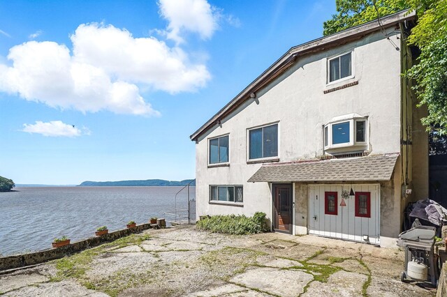 1 Battery Pl, Croton-On-Hudson, NY 10520 - view of front of property with a water view, stucco siding, and board and batten siding