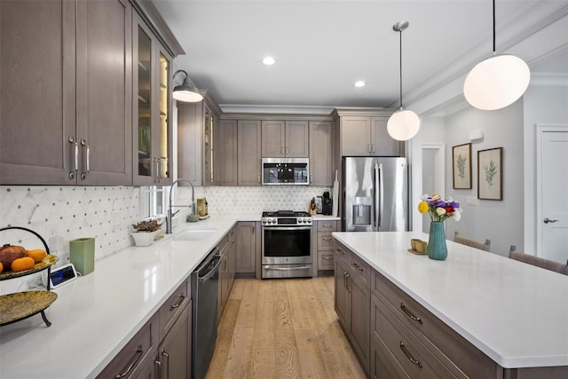 6 Livingston St, Red Hook, NY 12571 - kitchen with stainless steel appliances, a sink, light wood-style flooring, light countertops, and hanging light fixtures