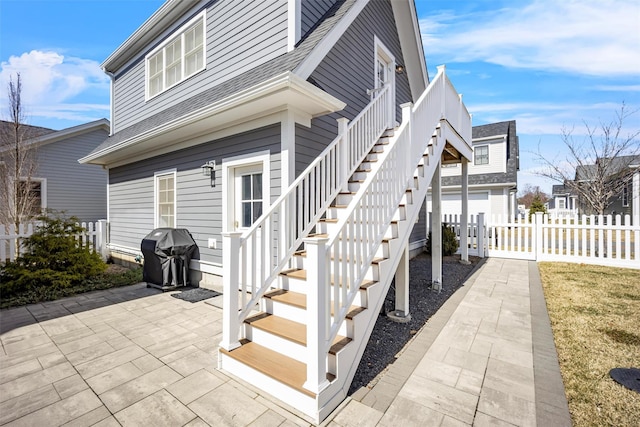 6 Livingston St, Red Hook, NY 12571 - view of property exterior with a patio, a shingled roof, and stairway