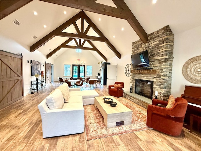 6 Livingston St, Red Hook, NY 12571 - living area with a barn door, wood finished floors, high vaulted ceiling, beam ceiling, and a chandelier