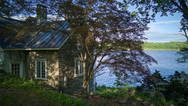 70 Floyd Ackert Rd, West Park, NY 12429 - view of home's exterior featuring a standing seam roof, stone siding, a water view, metal roof, and a chimney