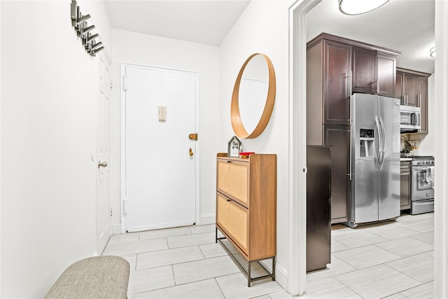 5 Bryant Cres Unit 1B, White Plains, NY 10605 - kitchen featuring appliances with stainless steel finishes, dark brown cabinets, baseboards, and light tile patterned floors
