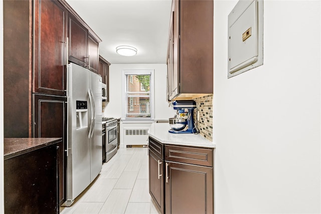 5 Bryant Cres Unit 1B, White Plains, NY 10605 - kitchen featuring radiator, appliances with stainless steel finishes, backsplash, dark brown cabinets, and light tile patterned floors