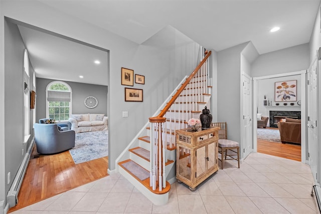 56 Londonderry Ln, Somers, NY 10589 - staircase with baseboard heating, tile patterned floors, recessed lighting, a high end fireplace, and a baseboard radiator