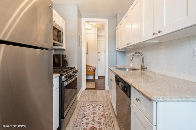 31 Pondfield Rd W Unit 68, Bronxville, NY 10708 - kitchen featuring stainless steel appliances, a sink, backsplash, light wood-type flooring, and white cabinetry