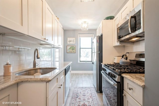 31 Pondfield Rd W Unit 68, Bronxville, NY 10708 - kitchen featuring stainless steel appliances, a sink, baseboards, tasteful backsplash, and white cabinetry