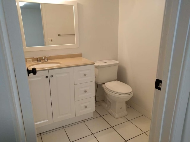 bathroom with tile patterned flooring, toilet, vanity, and baseboards