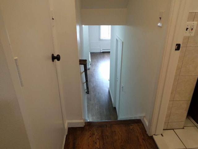 hall featuring a baseboard heating unit and wood finished floors